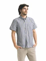 Camisa de hombre de manga corta con estampado a cuadros en tonos blanco, verde y marrón. Tiene cuello abotonado y bolsillo en el pecho.