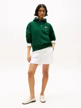 Buzo verde con capucha y cordón distintivo, bolsillo canguro, puños y bajo de punto canalé, logo oversize de Tommy Hilfiger en la manga y la parte trasera, parche con logo de Tommy Hilfiger en el pecho y detalles distintivos de Hilfiger Sailing.