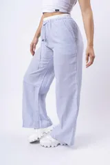 Pantalon de corte amplio y tiro bajo, confeccionado en tela de franela con estampado de cuadros en tonos blanco, negro y gris. Cuenta con cintura elástica con cordón ajustable y bolsillos laterales.