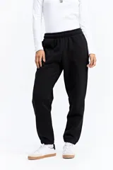 Pantalón tipo jogger de tiro medio con cintura elastizada y puños en los tobillos. Confeccionado en tejido de algodón y poliéster, presenta un diseño liso y holgado.