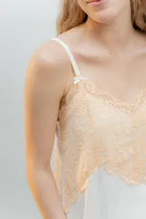 Camisón de algodón color beige con escote en V y ruedo decorados con puntilla gris. Presenta breteles finos y corte recto.