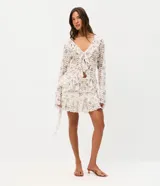 Pollera corta evasé de encaje floral Liberty, con volados asimétricos en capas y forro interno.