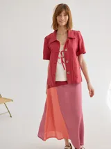 Chaqueta de lino color beige, con cuello camisero, manga corta y cierre frontal con botones de madera.