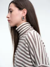 Polera de tejido de punto con diseño de rayas horizontales en tonos marrón y negro, cuello alto, mangas largas con hombros caídos y corte holgado.