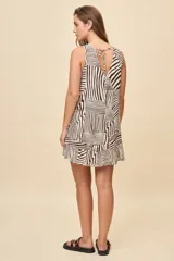 Vestido corto sin mangas de color celeste con estampado botánico en tonos marrones, de silueta amplia, escote redondo y volado en el ruedo.