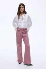 Jean de tiro alto con pierna amplia y corte holgado. Confeccionado en denim de algodón, presenta bolsillos delanteros con solapa y cierre de botón.