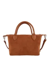 Cartera tipo bolso de mano color marrón, confeccionada en material con textura de gamuza. Presenta doble asa superior, correa larga ajustable y extraíble, y un detalle decorativo de labios en el frente junto al logo de la marca.