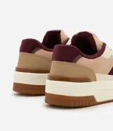 Championes urbanos de diseño moderno con recortes en tonos tierra y detalles en color bordó. Presentan suela tipo caja, cordones frontales, lengüeta acolchada y talón estructurado con acabado aterciopelado.