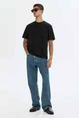 Remera negra de corte relajado, cuello redondo ribeteado, mangas cortas con hombros caídos y bajo recto, confeccionada con tejido liviano COOLMAX.
