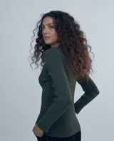 Polera gris de tejido de punto con cuello redondo y mangas largas. Presenta detalle de botones metálicos en los hombros y puños.