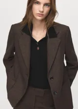 Jersey de punto color negro con cuello polo y cierre frontal de botones, de manga larga y diseño ajustado.