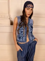 Chaleco de jean celeste con bordado floral monocromático en azul.