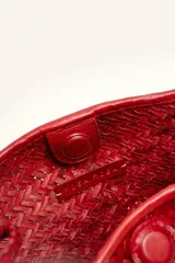 Cartera tipo morral y bandolera de cuero vacuno marrón, completamente trenzada a mano con diseño estructurado y correa larga trenzada.