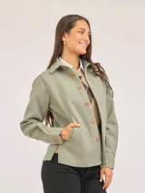 Sobrecamisa de paño color tostado, con cuello camisero, cierre frontal de botones y mangas largas con puños abotonados.