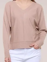 Buzo tejido fino de Allie Rose en color beige, con escote en V, costura central expuesta, mangas largas con puño ajustado y diseño relajado.