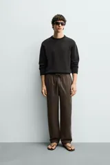 Pantalón de corte regular fit confeccionado en tejido mezcla de algodón, con cintura elástica ajustable mediante cordón, bolsillos laterales y bolsillos traseros de vivo.