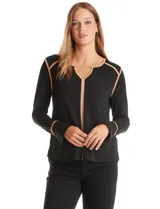 Blusa negra de crepe elastizado con ribetes en contraste color beige que recorren el escote en V, la línea central del frente y las costuras de los hombros. Tiene mangas largas con puños abiertos, abertura lateral y botón metálico.