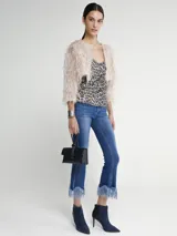 Saco corto color beige con plumas.