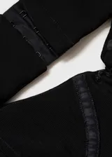 Vestido largo de fiesta color negro, con diseño recto y tirantes finos. Presenta un escote pronunciado y detalles cut-out en los laterales, con un bajo asimétrico y forro interior.