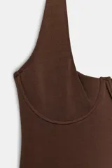 Body color marrón de cuello halter y escote corazón con aros metálicos ocultos. Presenta un diseño estilo corsé y cierre en el bajo con botones a presión.