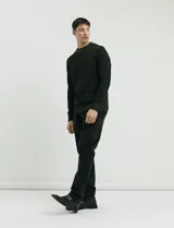 Sweater de punto con cuello redondo, manga larga y puños y ruedo acanalados. Presenta un diseño jaspeado en tonos oscuros.
