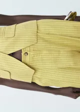 Pantalon de tiro alto con diseño recto y largo, confeccionado en tejido mezcla de lino, viscosa y lyocell con estampado de rayas verticales. Cuenta con cierre de botón y cremallera, además de detalle de pinzas y bolsillos laterales.