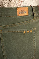 Pantalón wide leg de tiro medio en color verde oliva, confeccionado en tejido de algodón con mezcla de poliéster, liocel y elastano. Presenta diseño de cinco bolsillos, cierre frontal con botón y cremallera, y costuras a tono.