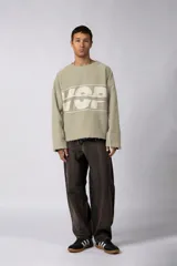 Buzo oversize de algodón rústico de alto gramaje, color beige, con diseño boxy, bordes con terminación cruda y estampa frontal con el texto VCP.