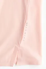 Musculosa deportiva rosada de corte estándar, confeccionada en tejido funcional DryMove que ayuda a absorber el sudor, con cuello redondo y aberturas laterales en el bajo.