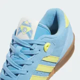 Championes Adidas Rivalry Low W, color celeste con detalles en amarillo y suela marrón.