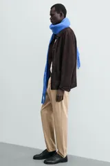 Pantalón chino de corte regular fit, confeccionado en tejido de algodón con elasticidad. Presenta bolsillos frontales, bolsillos traseros de vivo y cierre frontal con cremallera y botón.