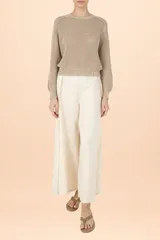 Sweater de punto color taupe, con cuello redondo, mangas largas abullonadas y puños ajustados. Presenta un tejido de punto grueso con textura.