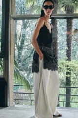 Top largo confeccionado en tejido de encaje con escote en pico y tirantes finos. Presenta una combinación de tejidos a tono con diseño sofisticado.