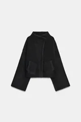 Chaqueta estilo bomber de punto color negro, con cuello subido, manga larga y cierre frontal cruzado con botones ocultos a presión. Presenta bolsillos delanteros de vivo.