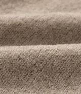 Sweater de punto color beige, con cuello alto y mangas largas acampanadas.