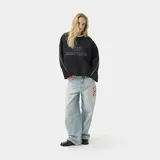 Buzo oversize de algodón color negro con cuello redondo. Presenta el logo de la marca bordado en el frente, líneas blancas en contraste a lo largo de las mangas y terminaciones con bordes deshilachados.