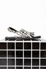 Sandalias chatas con tiras de cuero con estampado de cebra y base cuadrada.