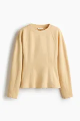 Buzo entallado de felpa color beige, con cuello redondo y mangas raglán largas, que presenta costuras moldeadoras en la cintura.