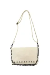 Bandolera color beige con solapa, detalles de tachas metálicas en la parte inferior y una cadena decorativa en el frente. Incluye correa ajustable para el hombro.