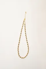 Collar corto de cuentas redondas doradas con cierre de mosquetón y cadena de extensión.