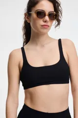 Top de bikini negro de textura acanalada, con escote cuadrado y tirantes anchos.
