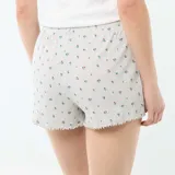 Pantalón corto de pijama gris melange con estampado de pequeñas flores y terminación de rulote en los bordes. Con cintura elástica.