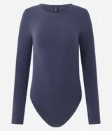 Body de manga larga con cuello redondo, confeccionado en tejido de poliamida y elastano sin costuras. Presenta un diseño ajustado al cuerpo con cierre inferior mediante botones de presión.