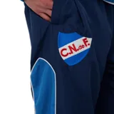Pantalón de jogging Umbro del Club Nacional de Football, color azul marino, con detalles laterales en celeste y blanco, escudo del club y logo de la marca bordados.