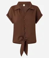 Blusa color marrón con cuello solapa, mangas cortas con vuelta y cierre frontal de botones. Cuenta con un diseño texturizado y un lazo para anudar en el bajo.
