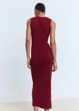Vestido midi entallado de color bordó, sin mangas, con cuello redondo y detalle drapeado en el lateral de la cintura. Presenta una joya decorativa en uno de los hombros.