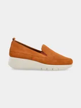 Mocasines slip-on de cuero nobuck color suela con diseño perforado en el empeine, elásticos laterales para facilitar el calce y suela plataforma de poliuretano blanca.