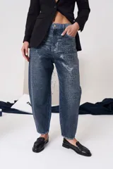 Jean de tiro medio con silueta slouchy y acabado texturado con estampado tipo cocodrilo. Cuenta con cierre frontal, botón metálico y bolsillos funcionales.