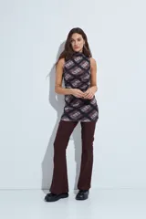 Vestido corto sin mangas con cuello alto, confeccionado en tela de red con estampado animal print en tonos gris y negro.