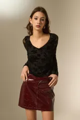 Top de manga larga con cuello en V, confeccionado en tela de tul con estampado floral aterciopelado en color negro.